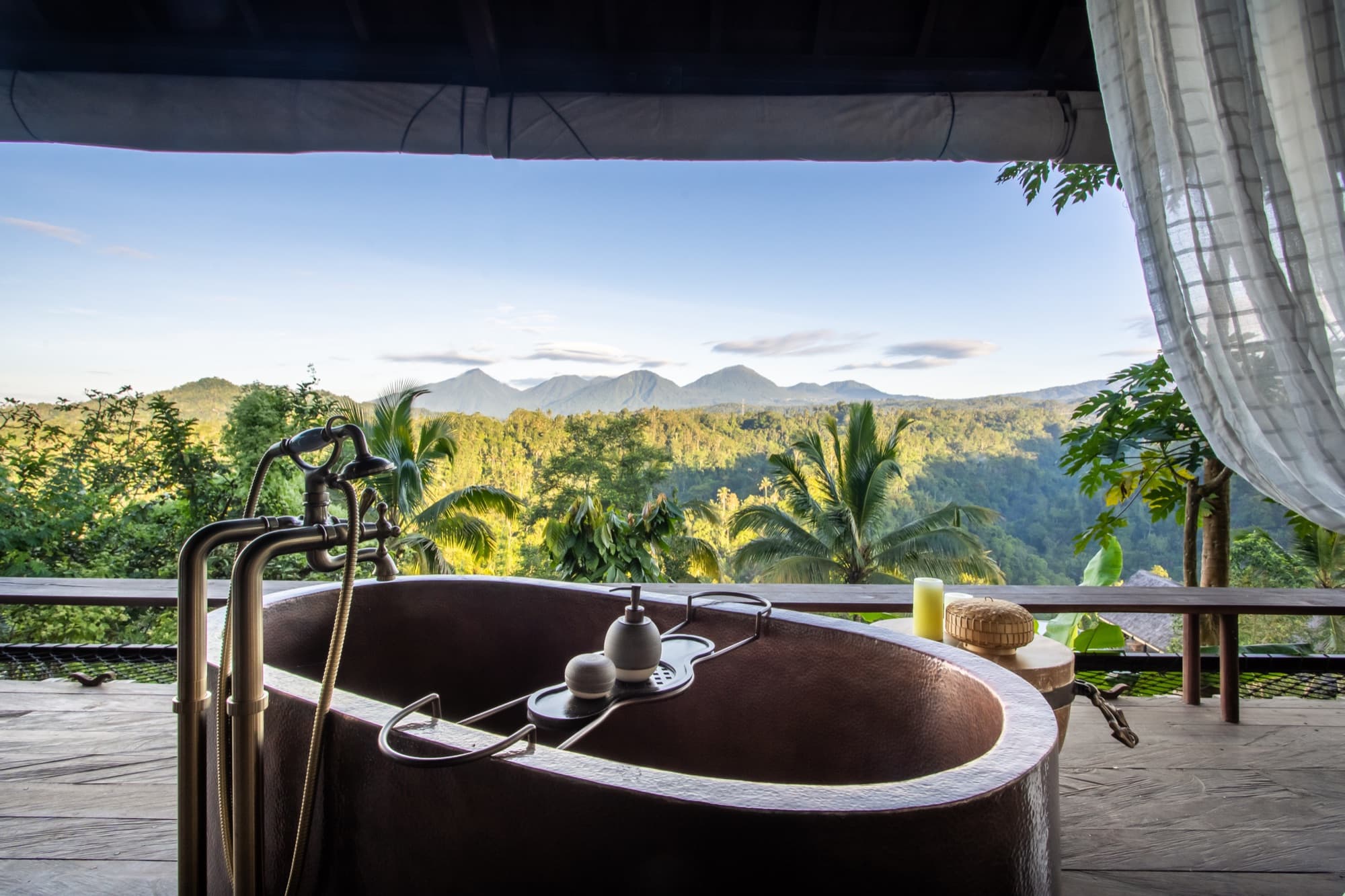 Hand-forged copper bathtub open to the jungle, with mountain views