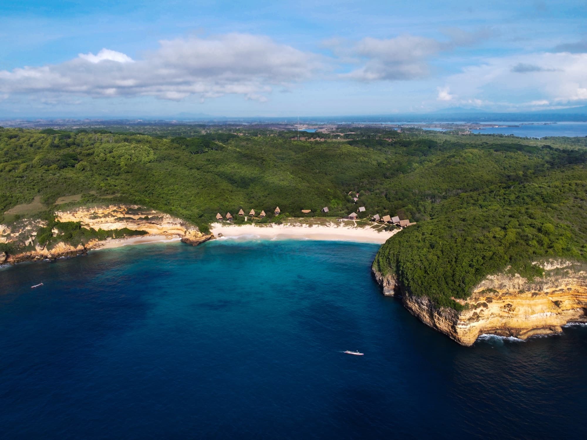 Aerial view of Jeeva Beloam Beach Camp from directly above — beach, A-frame lodges and turquoise sea, east Lombok