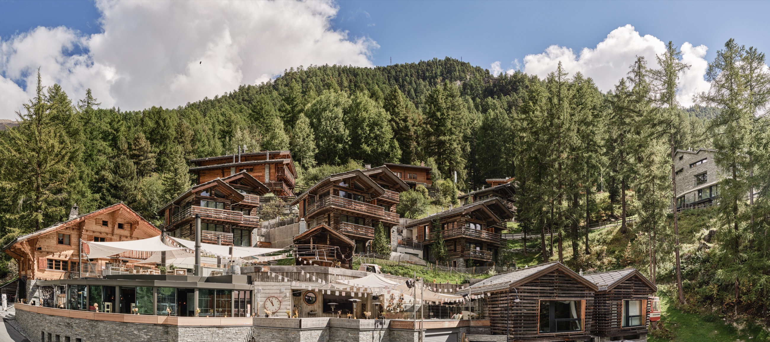Chalets of CERVO Mountain Resort on a forested slope above Zermatt in summer — mountain resort in Zermatt, Switzerland
